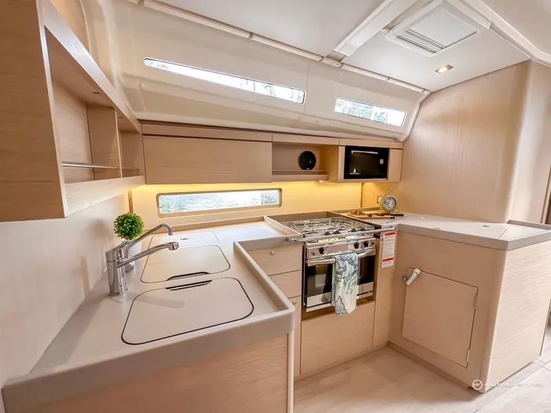Slide: The Image of Modern kitchen in 2024 Beneteau Oceanis 40.1 sailboat with stove, sink, and ample storage. - 9