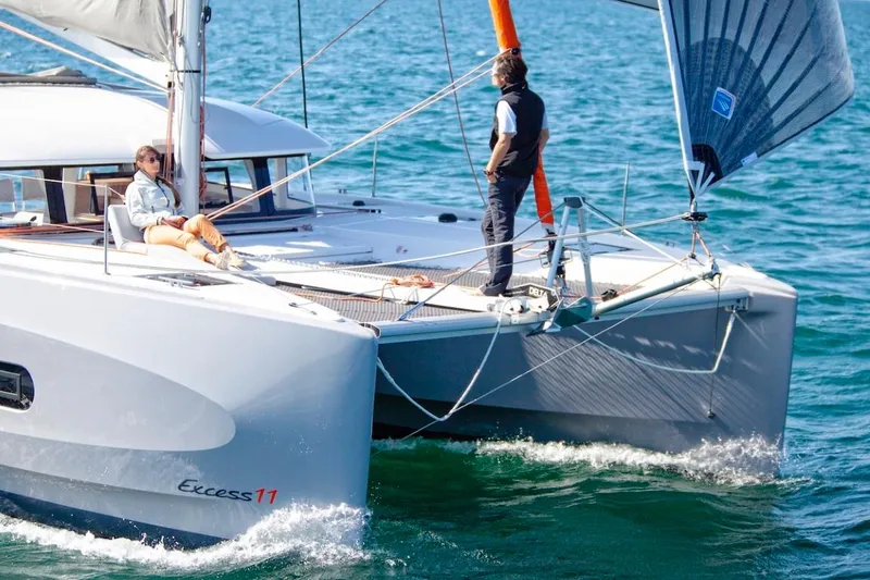 Slide: The Image of 2024 Excess 11 catamaran sailing with two people on deck. - 8