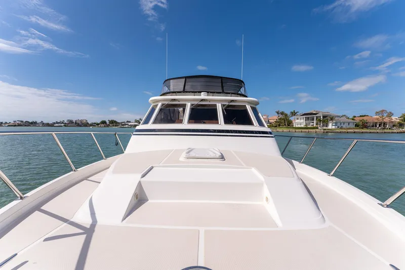 Slide: The Image of 1998 Offshore Yachts 54 Pilot House on calm waters, clear sky background. - 14