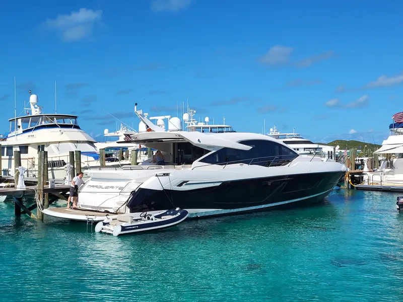 Slide: The Image of Sunseeker Predator 74 XPS 2020 yacht docked in a marina with clear blue water. - 0