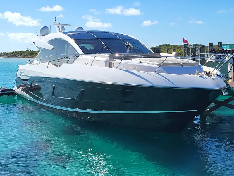 Slide: The Image of 2020 Sunseeker Predator 74 XPS luxury yacht docked in clear blue waters. - 2