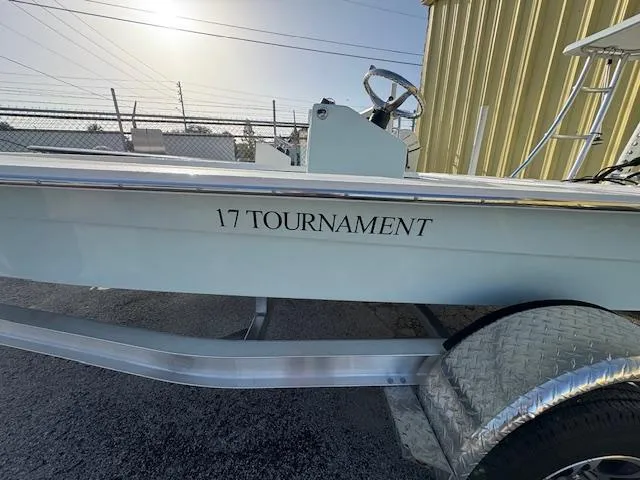 Slide: The Image of 2025 Mitzi Skiffs 17 Tournament boat on trailer, side view in sunlight. - 2