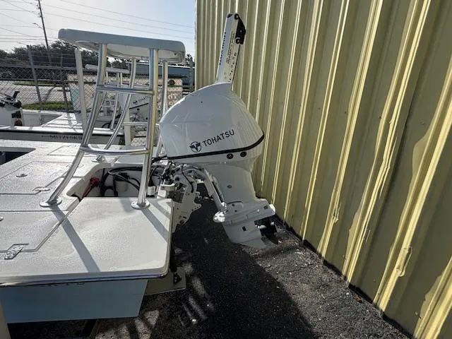 Slide: The Image of 2025 Mitzi Skiffs 17 with Tohatsu outboard motor, parked beside a yellow building. - 3