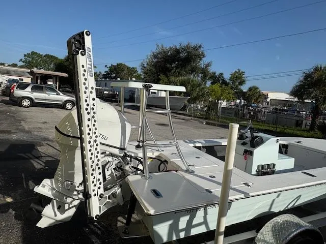 Slide: The Image of 2025 Mitzi Skiffs 17 boat with motor, parked outdoors on a sunny day. - 4