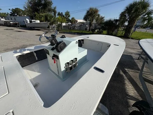 Slide: The Image of 2025 Mitzi Skiffs 17 boat with center console, parked outdoors on a sunny day. - 8