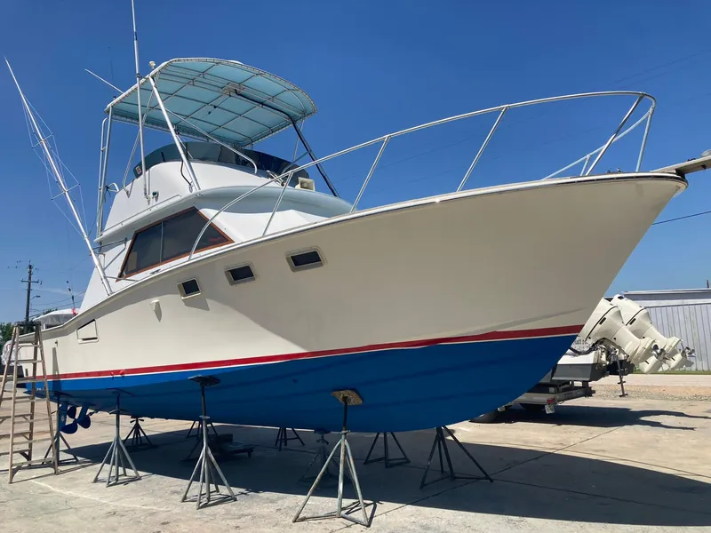 The Image of 1975 Custom 36 Matlack Tournament SF boat on stands, blue hull, white superstructure. - 0