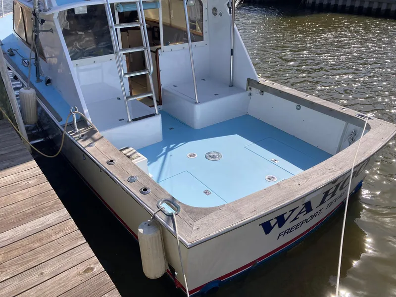 Slide: The Image of 1975 Custom 36 Matlack Tournament SF boat docked, featuring spacious deck and ladder. - 15