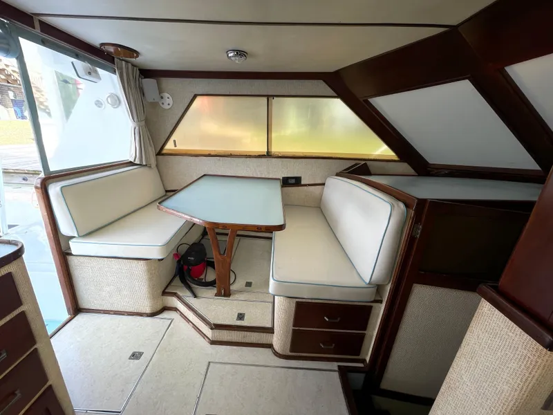 Slide: The Image of 1975 Custom 36 Matlack Tournament SF boat interior with dining area and cushioned seating. - 27