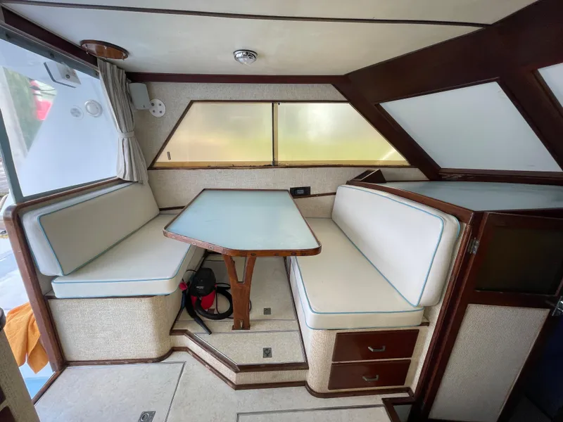 Slide: The Image of 1975 Custom 36 Matlack Tournament SF boat interior with dining area and cushioned seating. - 29