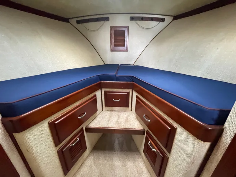 Slide: The Image of 1975 Custom 36 Matlack Tournament SF cabin with blue cushions and wooden storage drawers. - 40