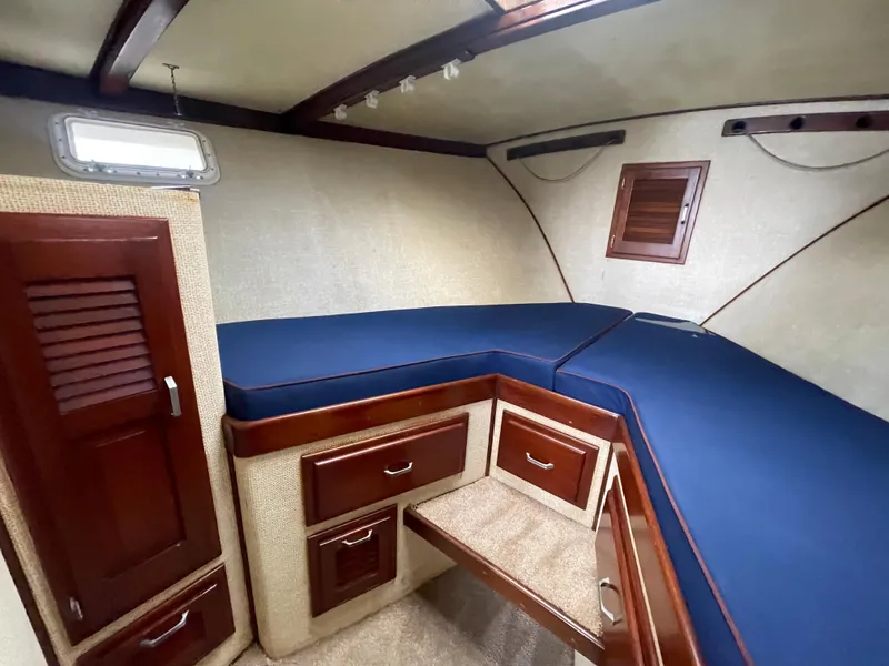 Slide: The Image of 1975 Custom 36 Matlack Tournament SF cabin with blue cushions and wooden storage cabinets. - 42