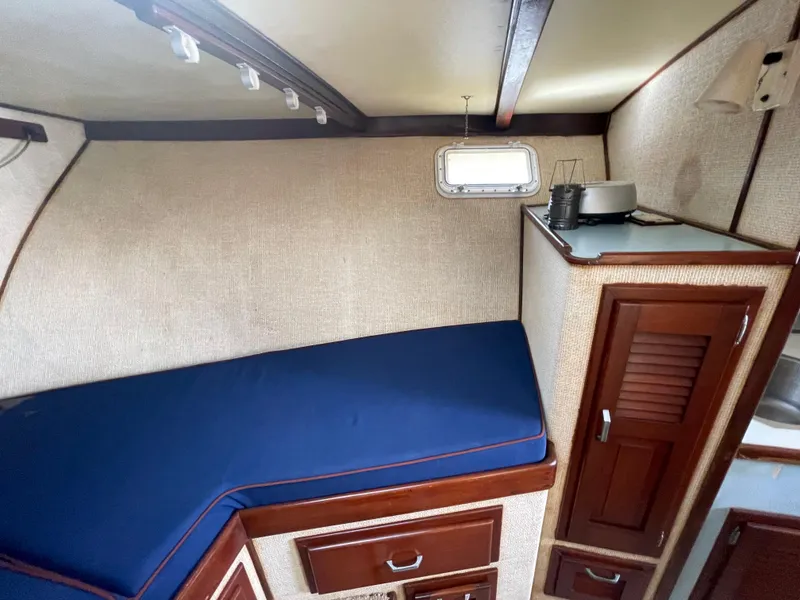 Slide: The Image of 1975 Custom 36 Matlack Tournament SF cabin interior with blue cushion and wooden cabinets. - 43