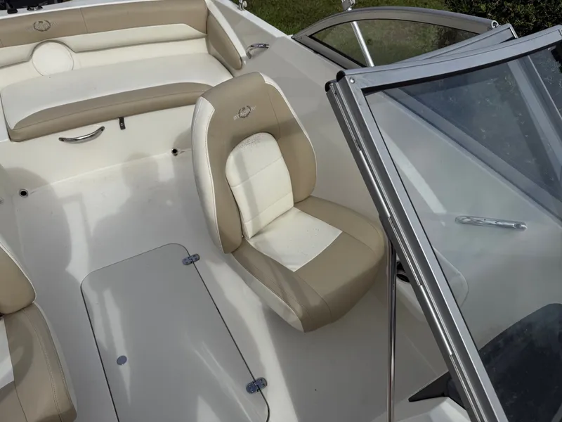 Slide: The Image of 2017 Stingray 191DC boat interior with beige and white seating, windshield, and storage compartment. - 10