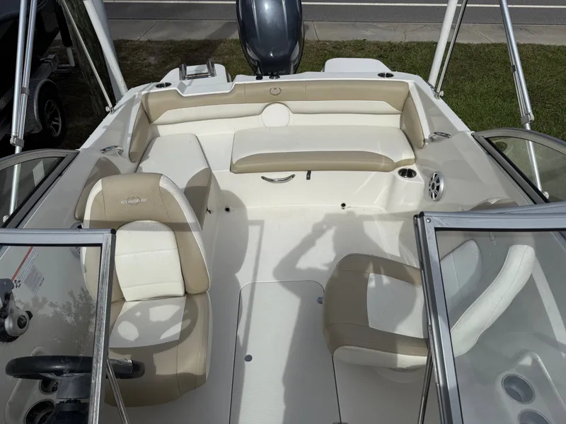 Slide: The Image of 2017 Stingray 191DC boat interior with beige seating and steering wheel. - 8