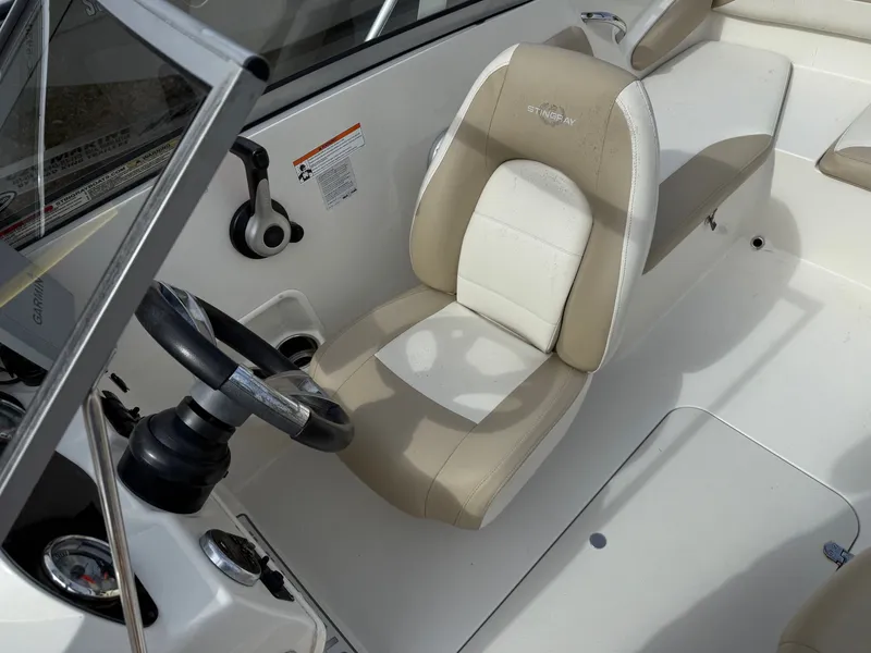 Slide: The Image of 2017 Stingray 191DC boat interior with beige and white seating and steering wheel. - 9