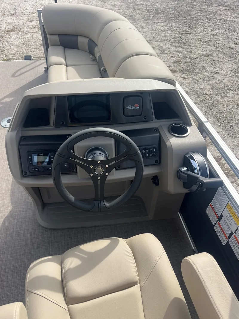 Slide: The Image of 2023 Sun Tracker Party Barge 22 RF DLX boat interior with steering console and seating. - 2