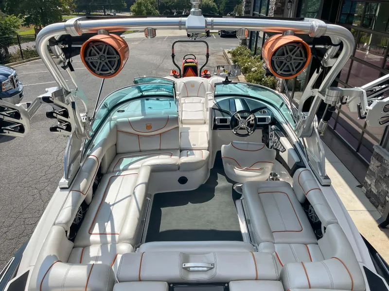 Slide: The Image of 2013 MasterCraft XStar boat interior with white leather seats and orange speakers. - 18