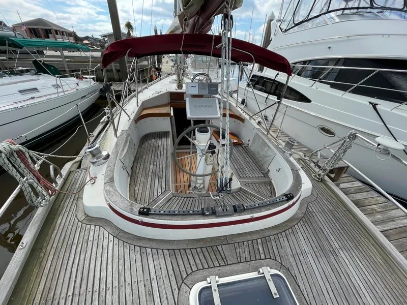 Slide: The Image of 1983 Najad 371 American CC sailboat cockpit with wooden deck and red canopy. - 12