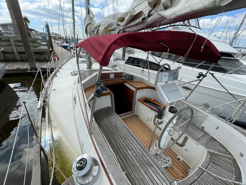 Slide: The Image of 1983 Najad 371 American CC sailboat with red canopy docked at marina. - 14