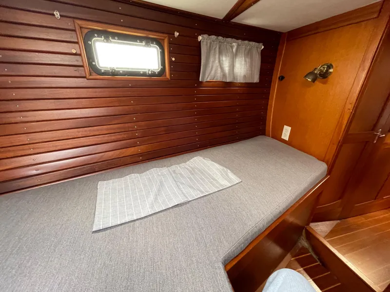 Slide: The Image of 1983 Najad 371 American CC cabin with wooden paneling and a single bed. - 23