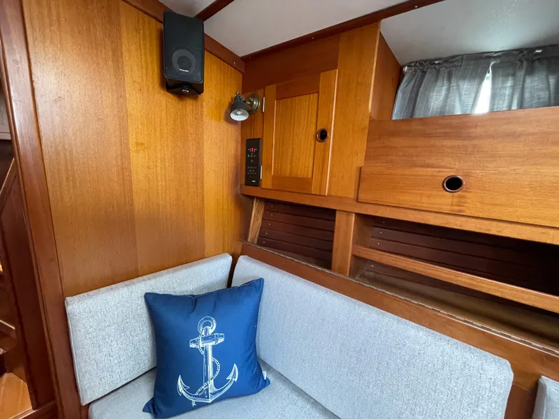 Slide: The Image of Interior of 1983 Najad 371 American CC sailboat with wooden paneling and anchor-themed pillow. - 27