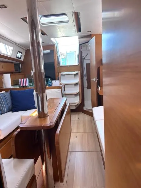 Slide: The Image of 2019 Jeanneau Sun Odyssey 389 interior with modern wood finish and seating area. - 14