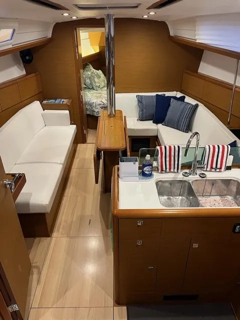 Slide: The Image of Interior of 2019 Jeanneau Sun Odyssey 389 yacht with modern kitchen and cozy seating area. - 17