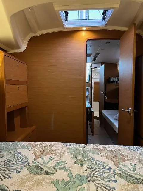 Slide: The Image of Interior of 2019 Jeanneau Sun Odyssey 389 sailboat, featuring cozy cabin and open bathroom door. - 19