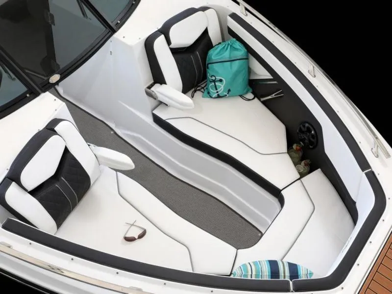 Slide: The Image of 2023 Monterey 278SS boat interior with white and black seating, teal bag, and sunglasses. - 2