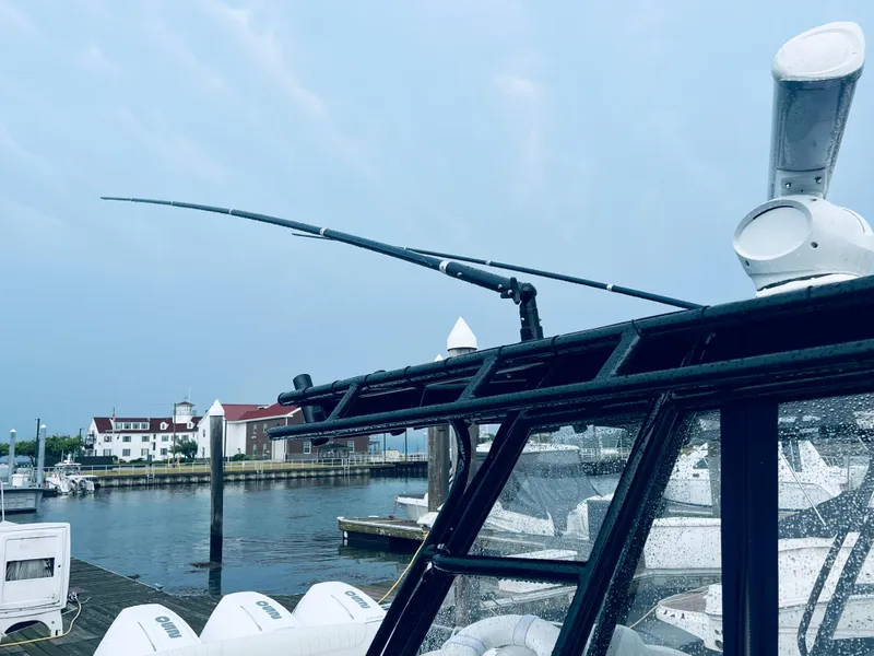 Slide: The Image of 2004 Fountain 38 LX boat docked at a marina with a scenic waterfront view. - 10
