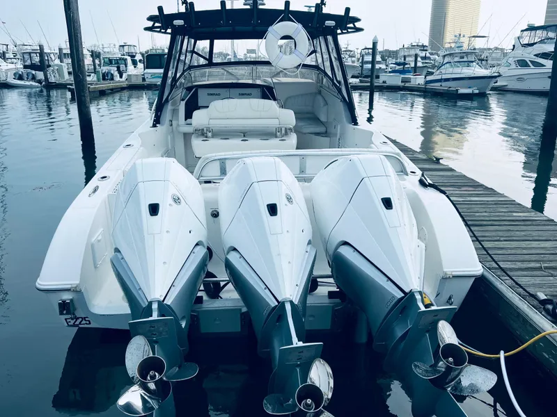 Slide: The Image of 2004 Fountain 38 LX boat with triple outboard engines docked at marina. - 11