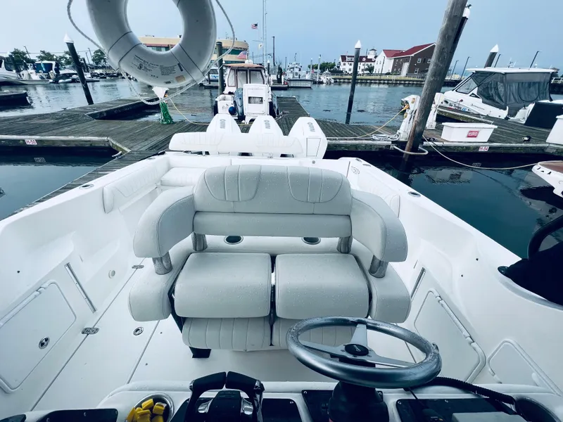 Slide: The Image of 2004 Fountain 38 LX boat interior at marina, featuring helm and seating. - 13