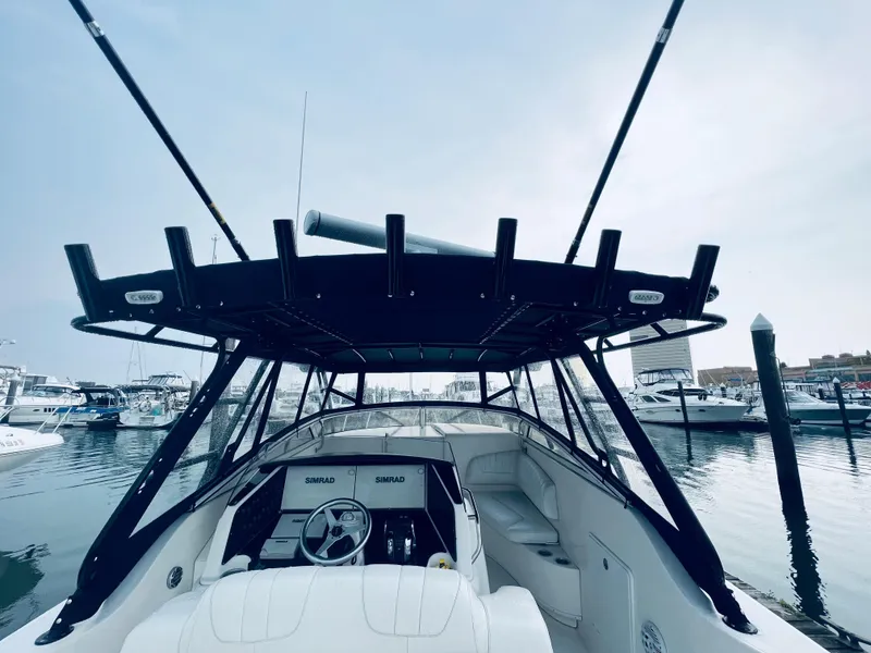 Slide: The Image of 2004 Fountain 38 LX boat docked at a marina, view of the helm and seating area. - 16