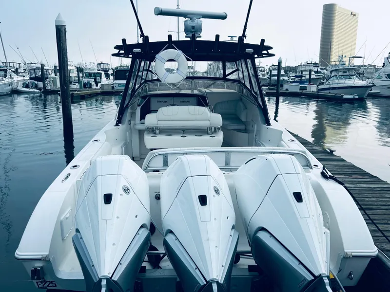 Slide: The Image of 2004 Fountain 38 LX boat with triple outboard engines docked at marina. - 19