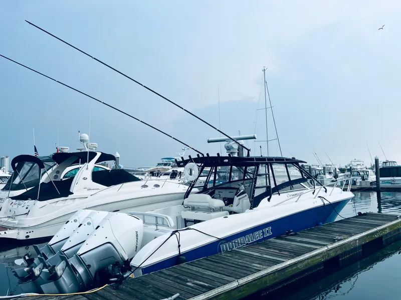 Slide: The Image of 2004 Fountain 38 LX boat docked at marina with other yachts. - 2