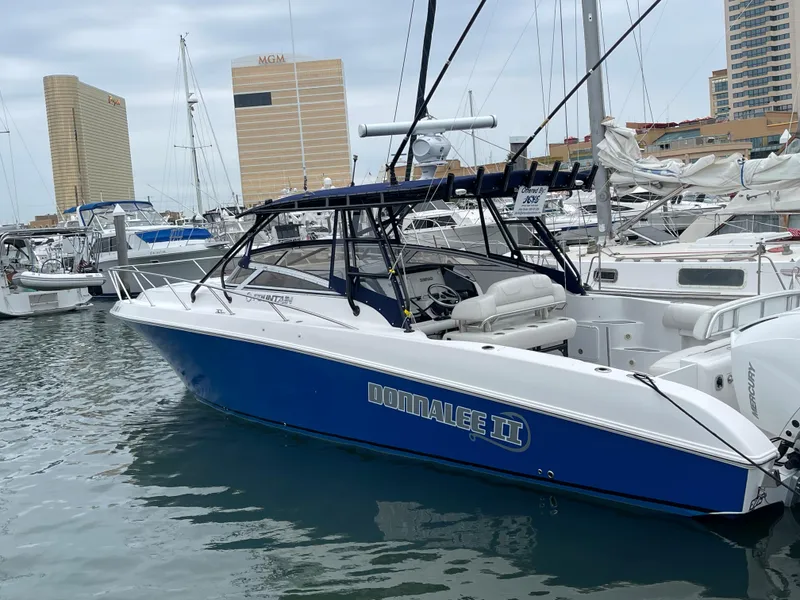 Slide: The Image of 2004 Fountain 38 LX boat docked in marina with cityscape background. - 20