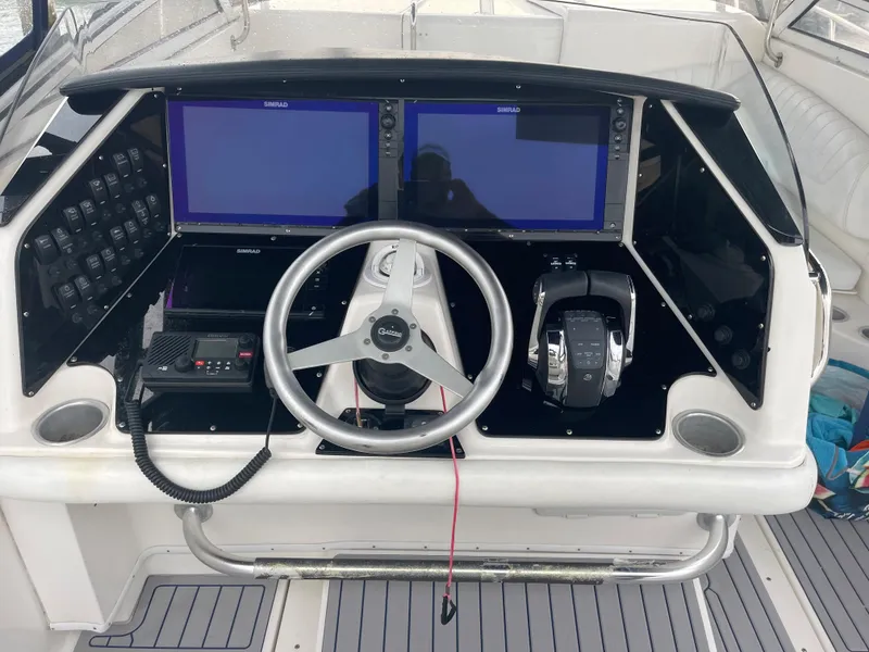 Slide: The Image of 2004 Fountain 38 LX boat dashboard with dual screens and steering wheel. - 21
