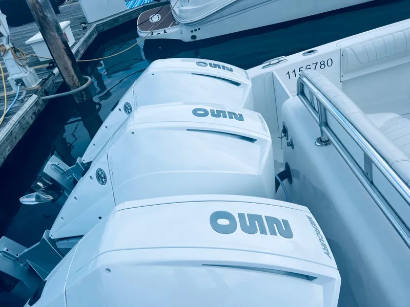 Slide: The Image of 2004 Fountain 38 LX boat with triple outboard engines docked. - 4