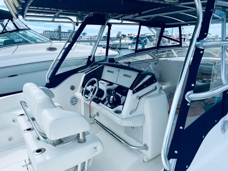 Slide: The Image of 2004 Fountain 38 LX boat interior with white seating and modern dashboard. - 7