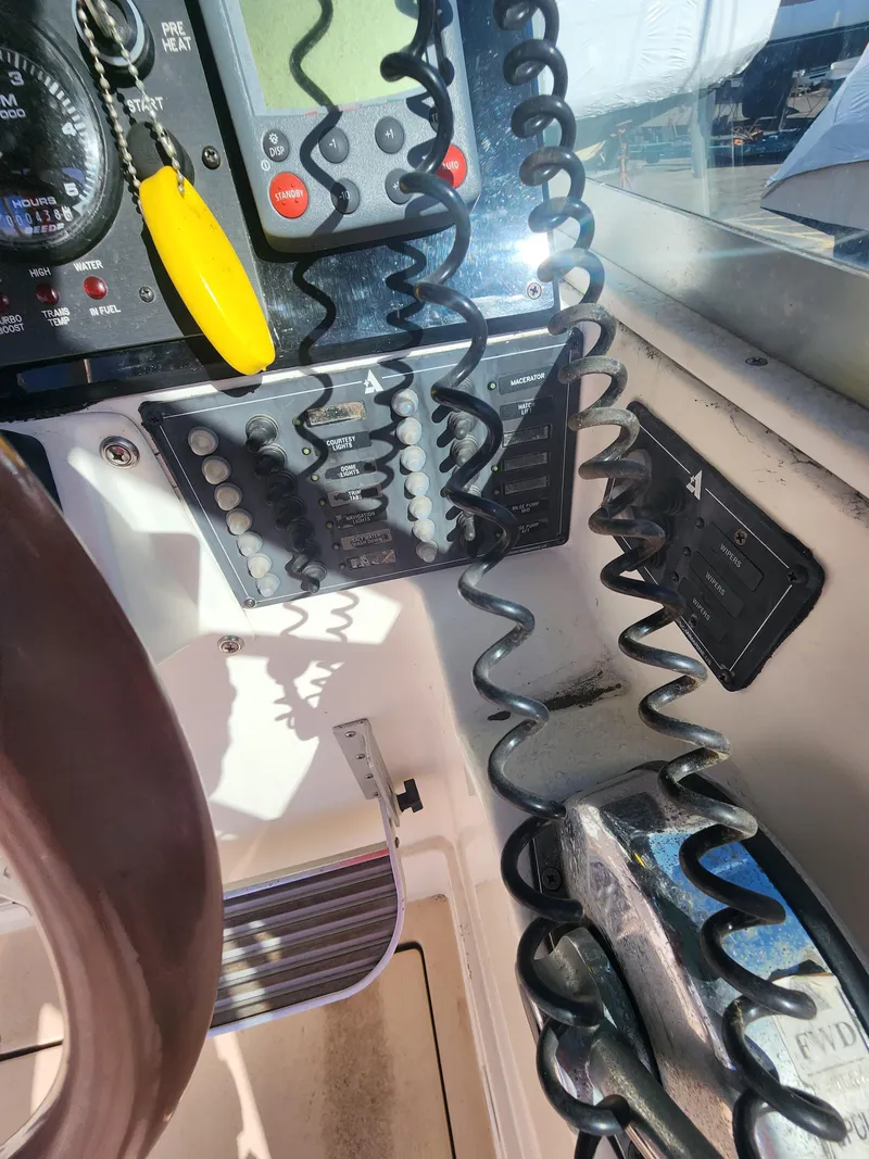 Slide: The Image of Control panel of a 2005 Albin 28 boat with coiled cables and navigation instruments. - 10