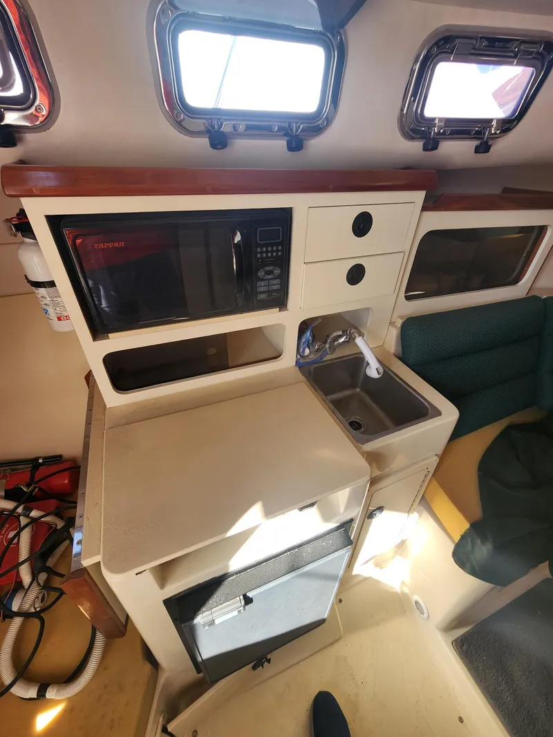 Slide: The Image of Compact kitchen area in a 2005 Albin 28 boat with microwave and sink. - 11