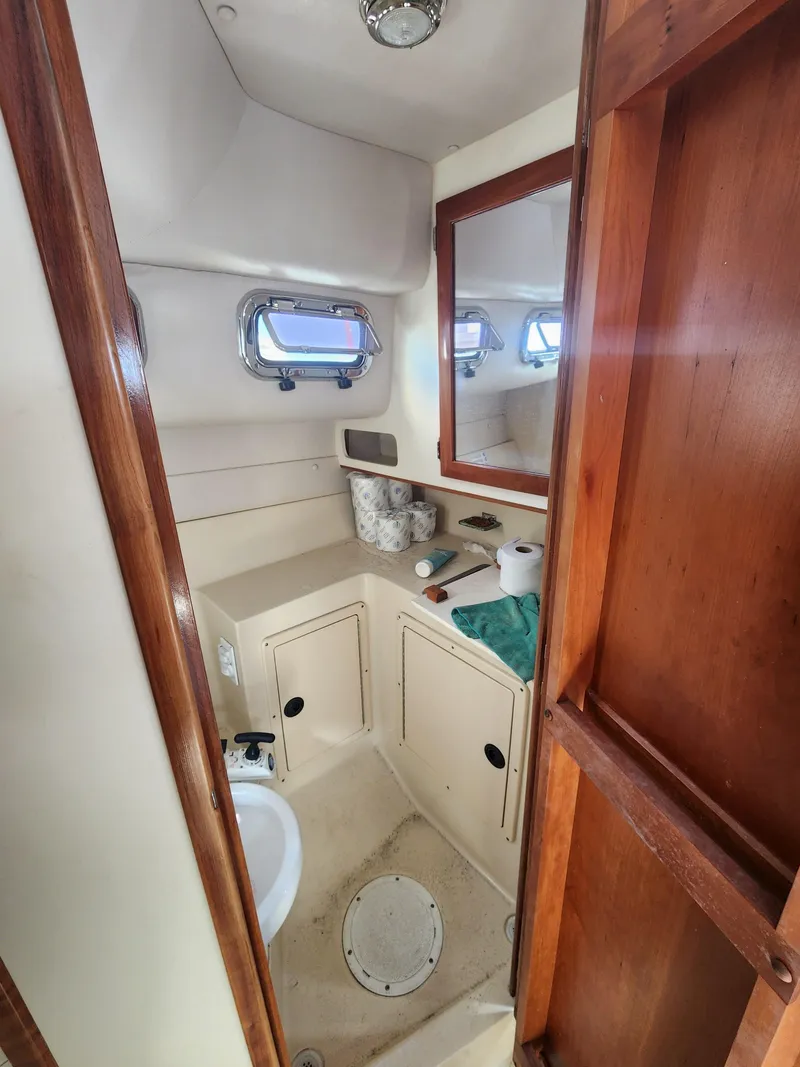 Slide: The Image of 2005 Albin 28 boat bathroom with wooden accents and porthole windows. - 12