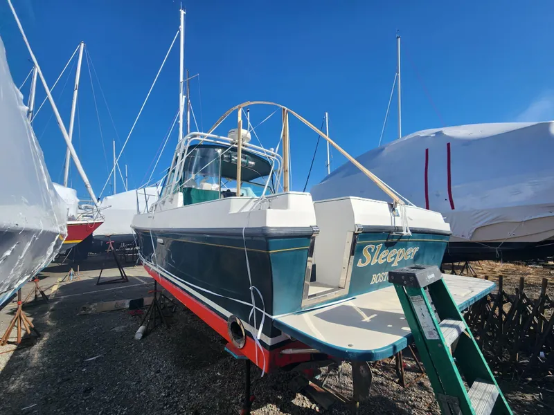 Slide: The Image of 2005 Albin 28 boat named "Sleeper" on dry dock, surrounded by other vessels. - 3
