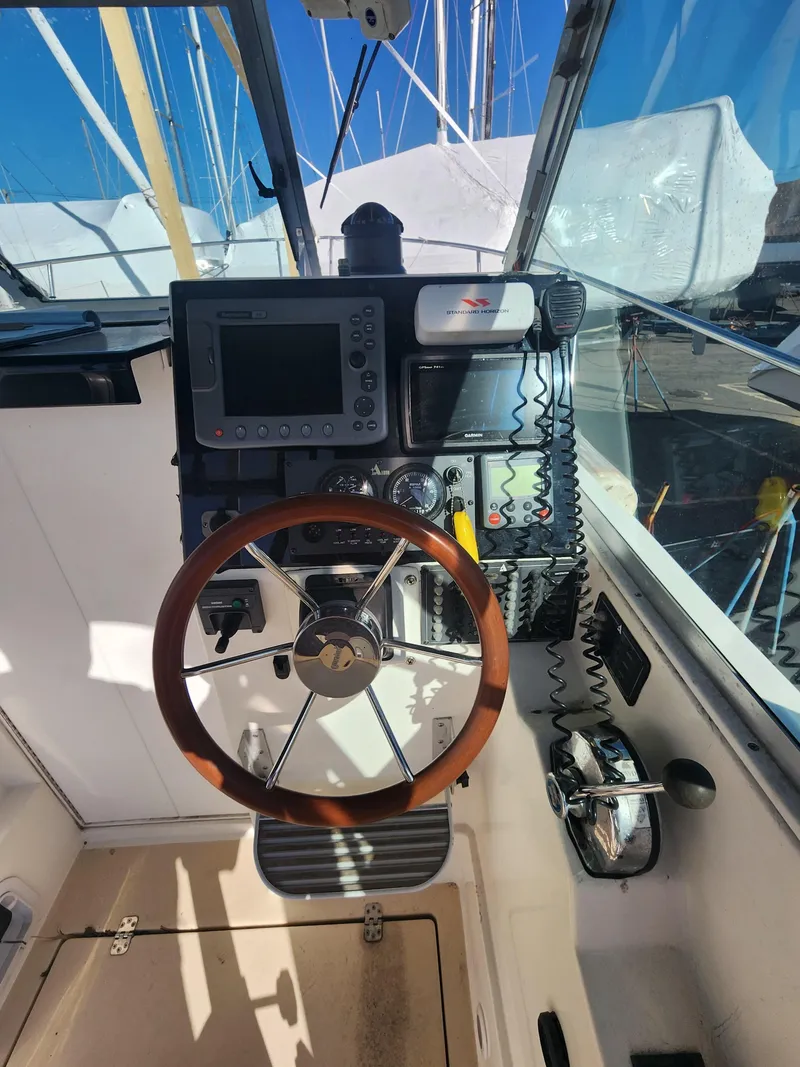 Slide: The Image of 2005 Albin 28 boat helm with wooden steering wheel and navigation equipment. - 9