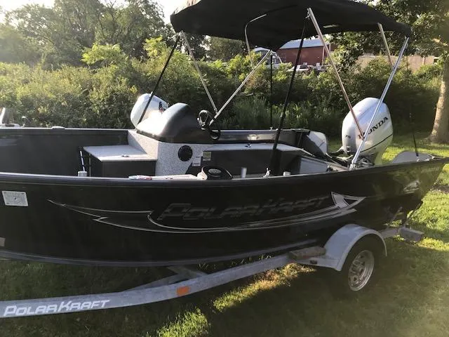 Slide: The Image of 2023 Polar Kraft Outlander 165 SC boat on a trailer in a grassy area. - 2