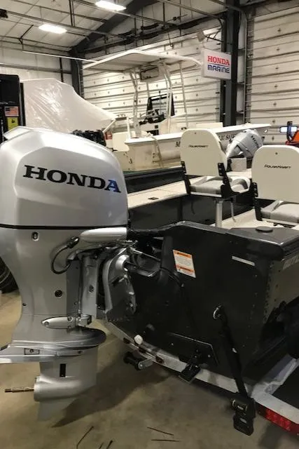 Slide: The Image of 2023 Polar Kraft Outlander 165 SC boat with Honda outboard motor in a showroom. - 8