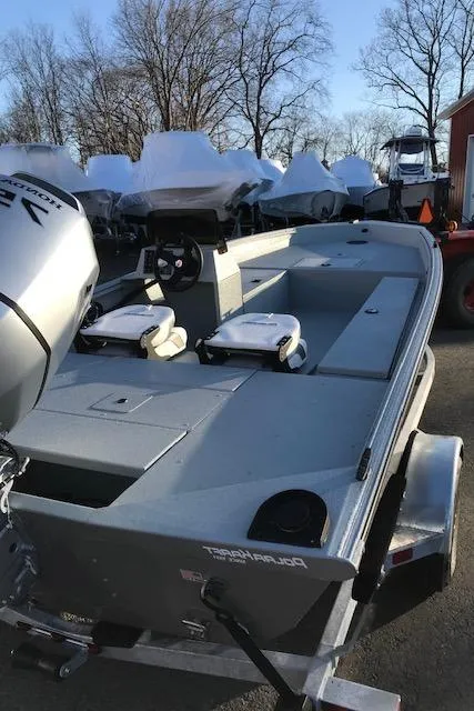 Slide: The Image of 2023 Polar Kraft Sport X boat with motor, parked outdoors. - 2