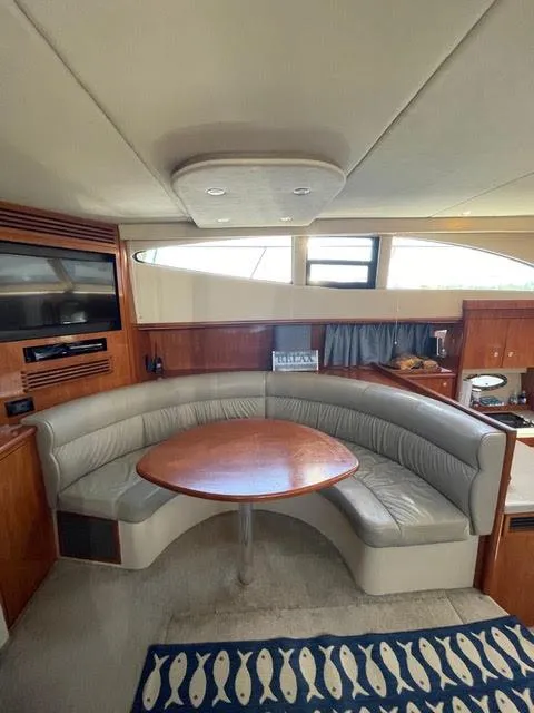 Slide: The Image of Interior of 2006 Cruisers Yachts 385 Motoryacht with curved seating and wooden table. - 10