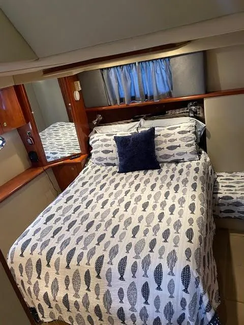 Slide: The Image of 2006 Cruisers Yachts 385 Motoryacht bedroom with patterned bedding and wooden accents. - 11