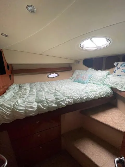 Slide: The Image of 2006 Cruisers Yachts 385 Motoryacht bedroom with bed, porthole, and steps. - 14